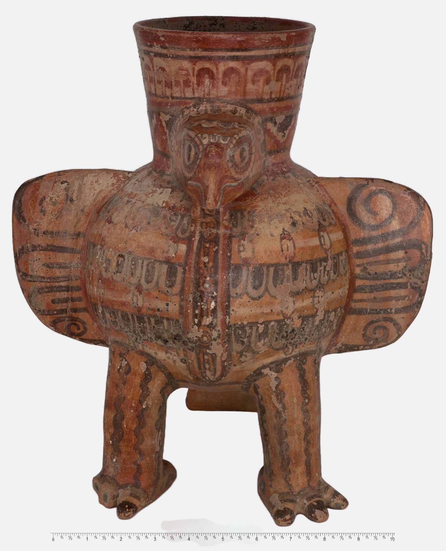 Front view of a clay pot shaped like an eagle, with rows of feathers and a tail.